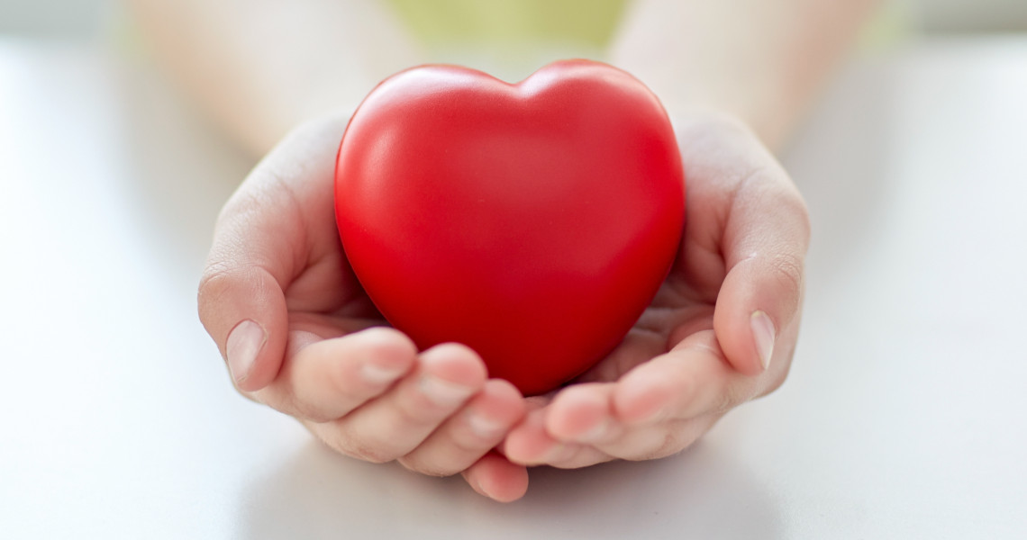 close up of child hands holding red heart